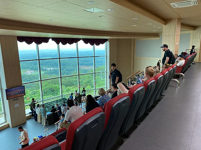 An auditorium looking through large windows at the green, undeveloped lands of the Korean DMZ.