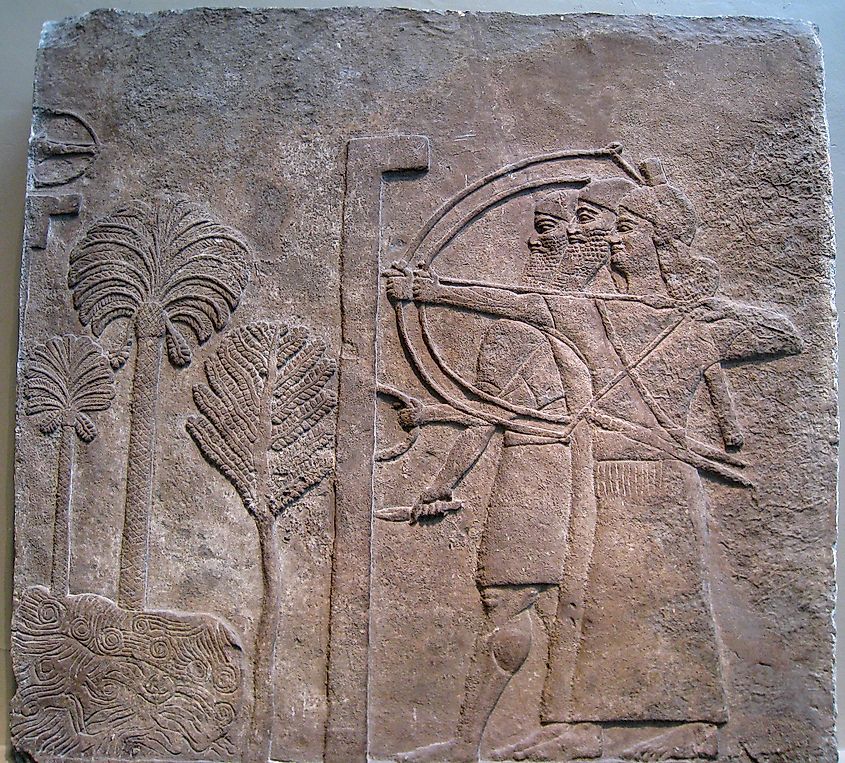 Ancient relief of Assyrian archers using recurved bows, illustrating the battlefield role of the composite bow.