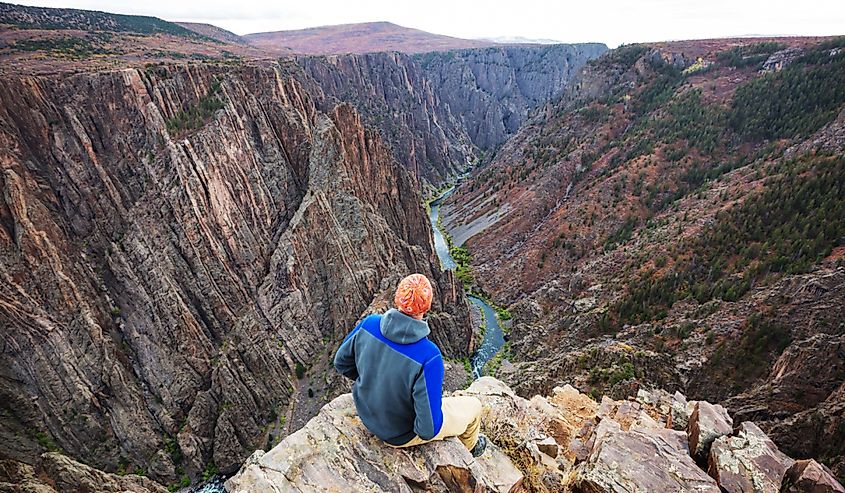 Tourist on the granite cliffs of the Black Canyon of the Gunnison, Colorado.
