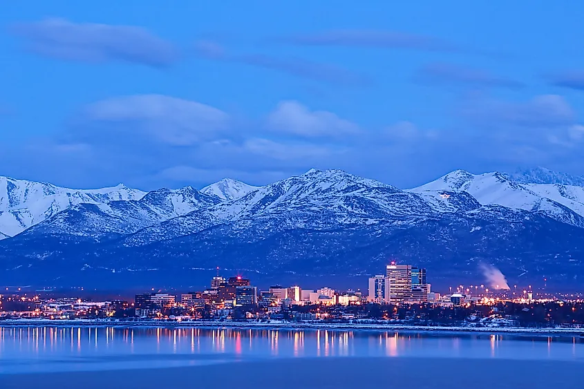 The skyline of Anchorage, Alaska, with mountains behind.