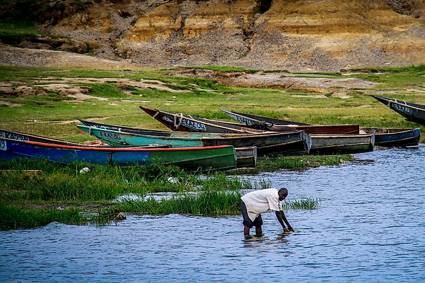 A man washes his hands in the Kazinga Channel linking Lake Edward and Lake George