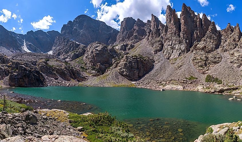 Sky Pond - A panoramic overview of clear and colorful Sky Pond, with Taylor Peak, Taylor Glacier and The Sharkstooth towering at shore, on a sunny Summer day. Rocky Mountain National Park, CO, USA.