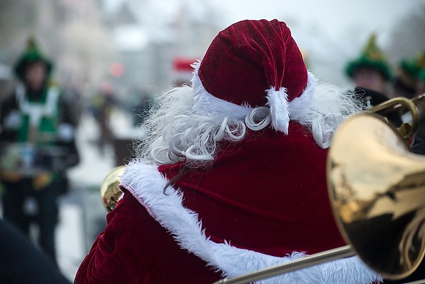Portrait on back view of man wearing a santa claus costume in the street. NeydtStock via Shutterstock