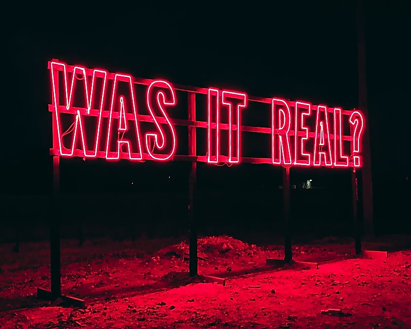A red neon sign in Marfa, Texas, reads, "WAS IT REAL?"