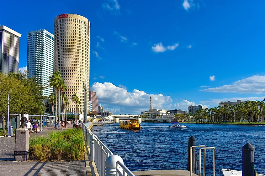 Partial view of skycrapers , riverwalk and water taxi sailing on Hillsborough river in downtown area of Tampa Bay, via VIAVAL TOURS / Shutterstock.com