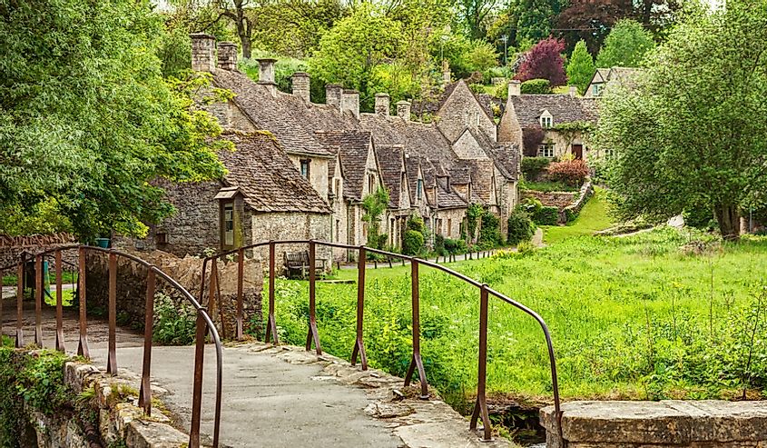 Old footbridge and traditional Cotswold cottages, Bibury, England