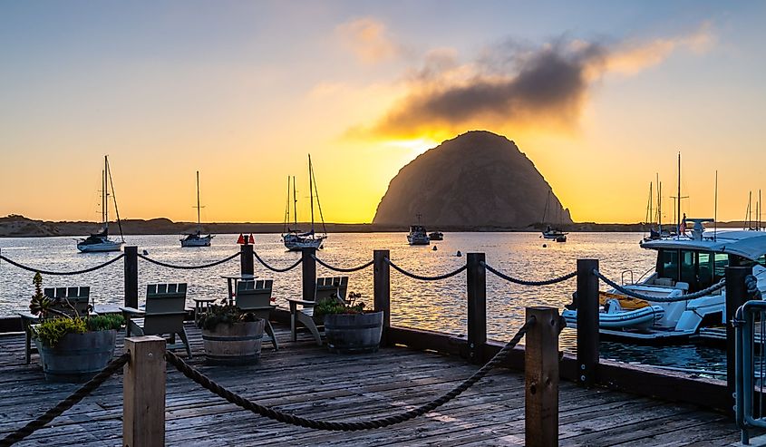 Morro Bay State Beach, California, sun setting behind a large rock