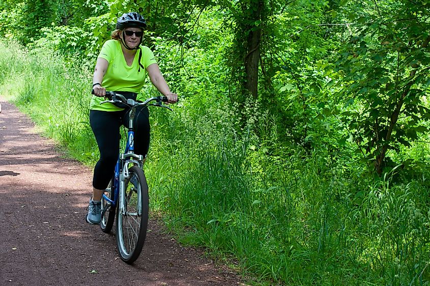 A woman on a bicycle on a trail in Raritan-Delaware Canal State Park in Somerset County, New Jersey