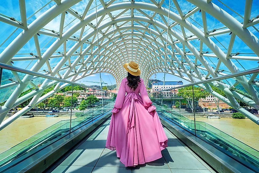 Tourist walking on bridge of peace in Tbilisi, Georgia.