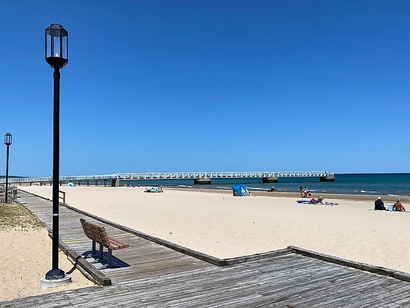 A pretty beach with a boardwalk and pier.