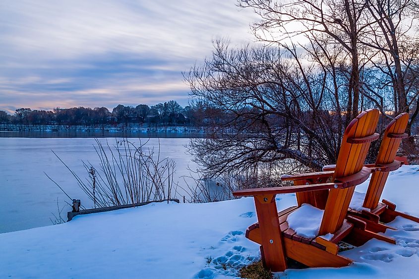 Chairs for relaxation by the edges of the Spy Pond in Arlington, Massachusetts, during winter