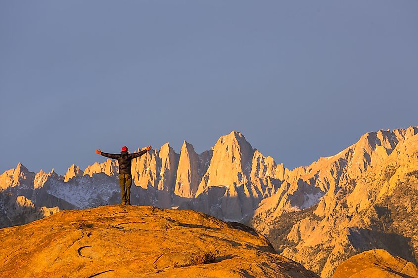 A hiker enjoying the beauty of Mount Whitney and surrounding landscape.