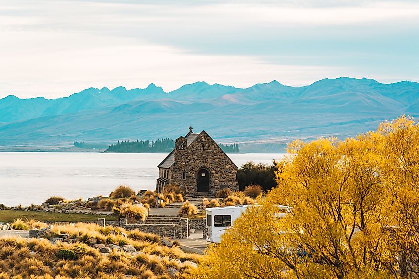 Beautiful famous Church of the Good Shepherd with mountain and yellow grass in autumn park at Lake Tekapo, New Zealand