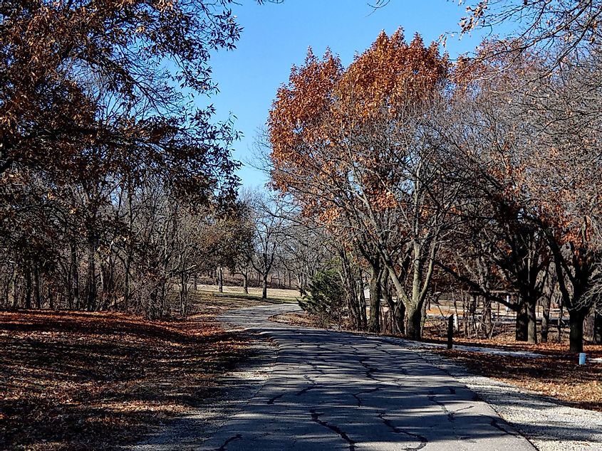 Old paved road through Fall trees at Canning Creek near Council Grove, Kansas