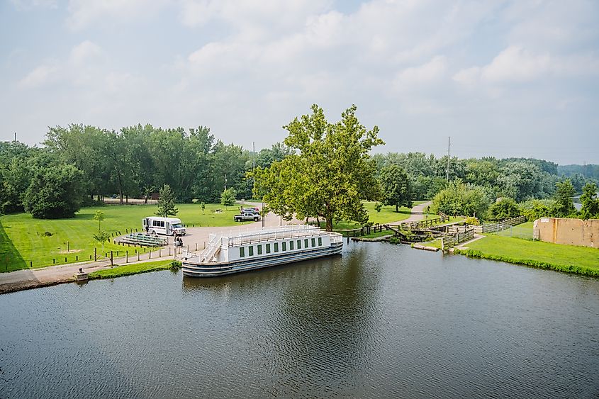 The Illinois and Michigan Canal on a sunny day in La Salle, Illinois. In the water sits The Volunteer, an 1848 replica canal boat that carries visitors on 60- and 90-minute trips through the canal and its history. Wikimedia Commons. 