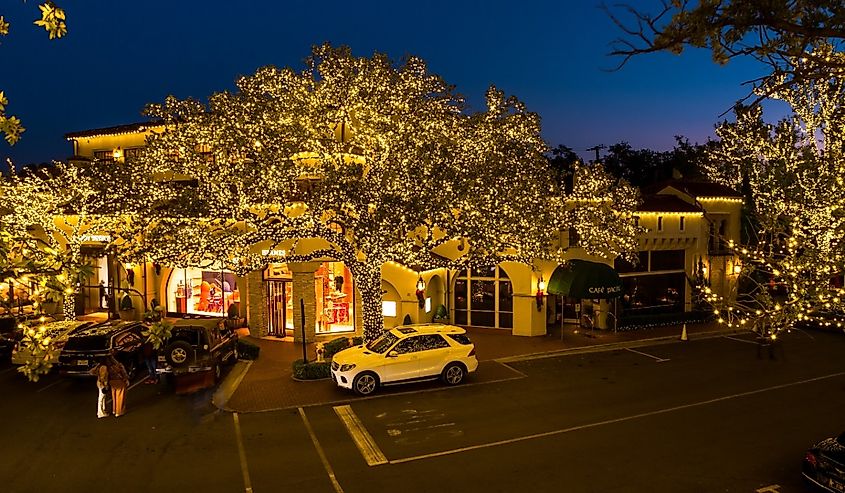 Exterior of the Cafe Pacific and other businesses illuminated for the holiday season, Highland Park Village, Texas.
