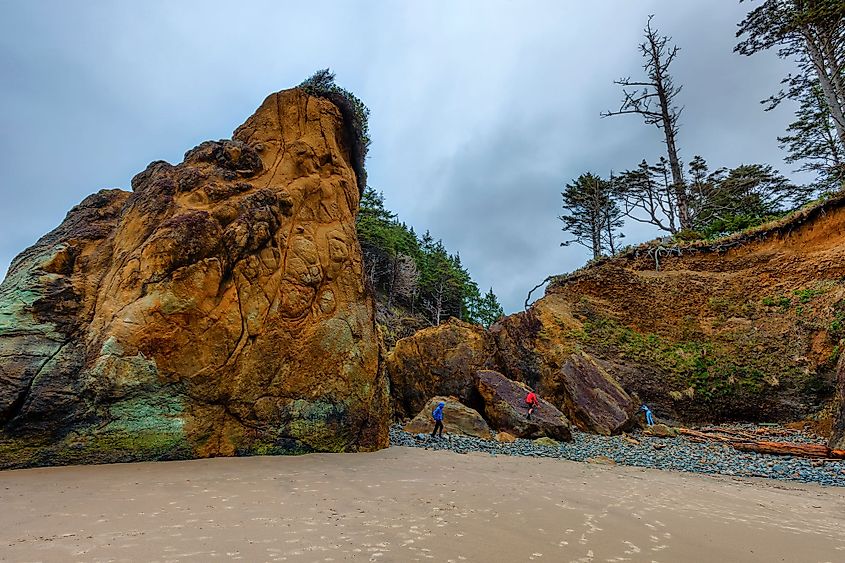 Three young teens play on sandstone rocks on Arcadia Beach, near Cannon Beach, Oregon