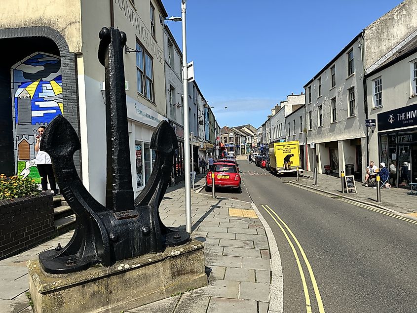 The town centre and pedestrian areas with local shops and traffic passing through. Urban furniture and monuments.