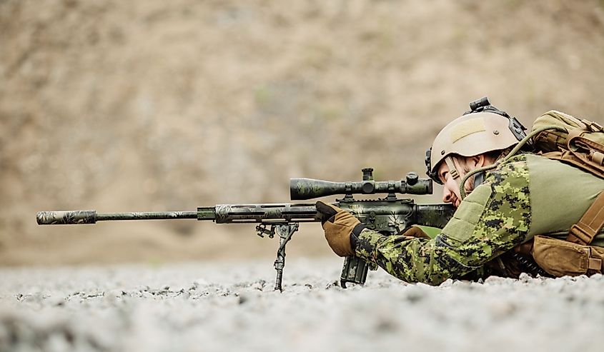 armed man in camouflage with sniper gun in hands