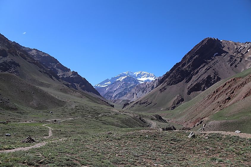 Snowy Mount Aconcagua Peak surrounded by mountains and Hiking Trail.
