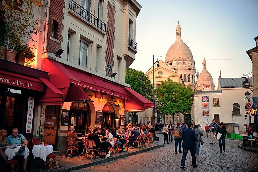 Downtown City street view in Paris, France with people sitting on patios