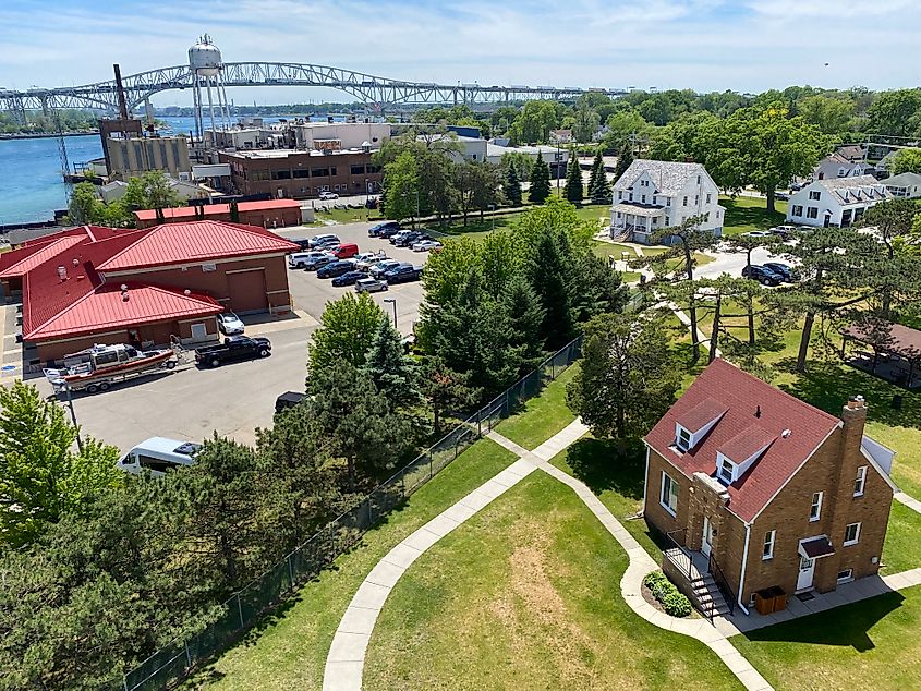 A large steel bridge crosses a wide river in the background of a historic fort.