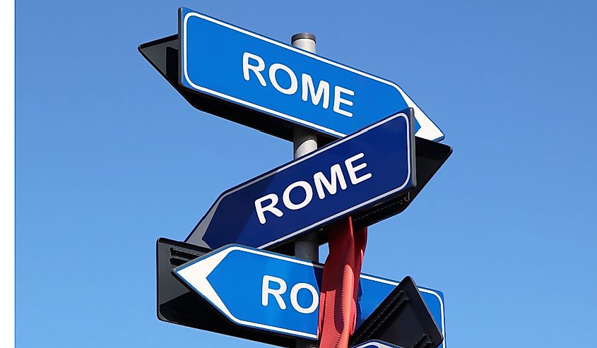 Street sign with Rome city name on blue sky background. All roads lead to Rome quote