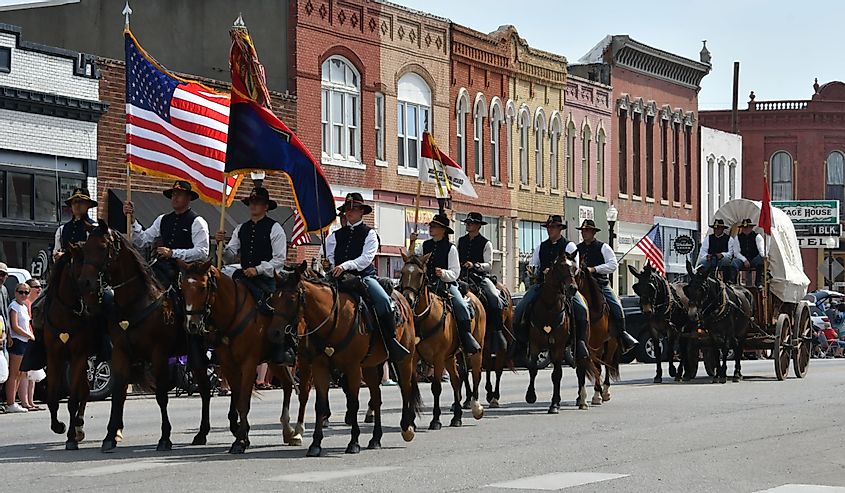 Members of the Fort Riley Commanding General's Mounted Color Guard outfitted in the uniforms and equipment of the Civil War ride in the Washunga Days Parade, Council Grove, Kansas