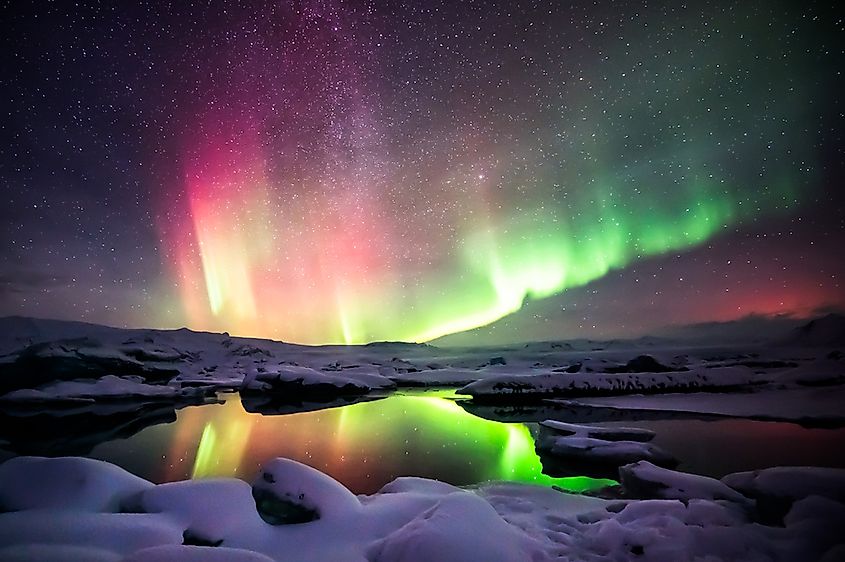 A beautiful green and red aurora dancing over the Jokulsarlon lagoon, Iceland