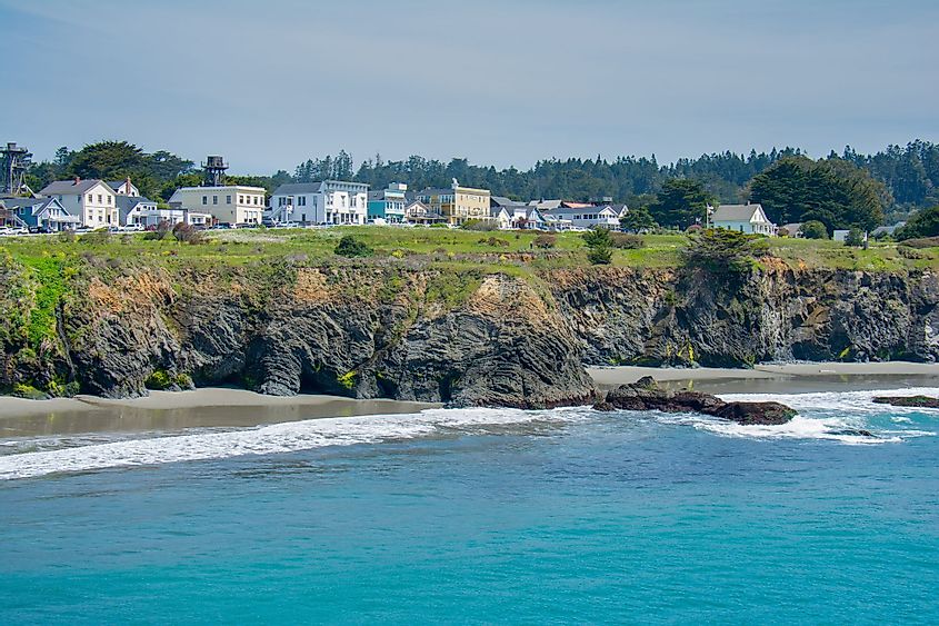 The seacoast village of Mendocino, California, lines an ocean headland at low tide on a sunny spring afternoon.