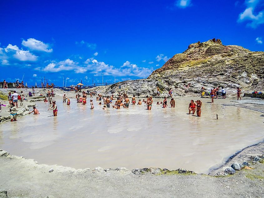 people having a mud and sulfur bath on the volcanic island.