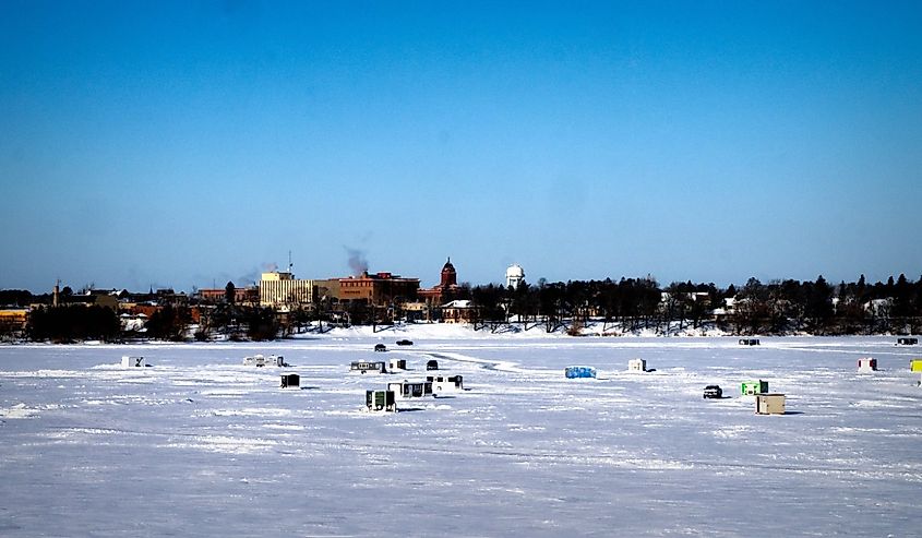 Winter Fishing Houses on frozen Lake Bemidji in Minnesota on a late December morning with City of Bemidji, Minnesota