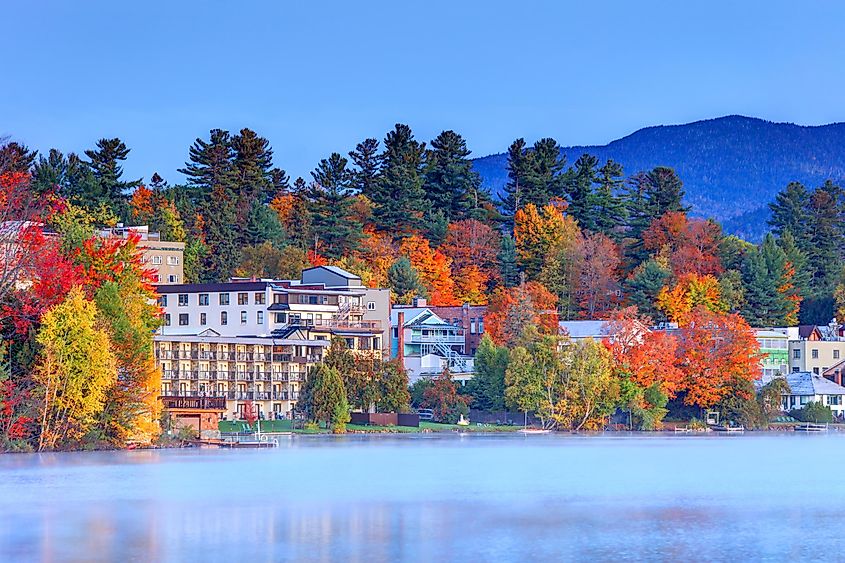 Homes along the water with autumn colors in Lake Placid, New York.