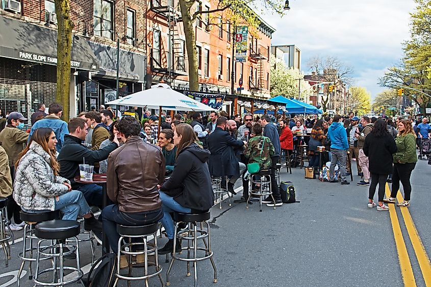 crowds of people enjoy a drink and socializing on Brooklyn's 5th avenue which is closed to traffic on Saturday afternoons, via Mystic Stock Photography / Shutterstock.com