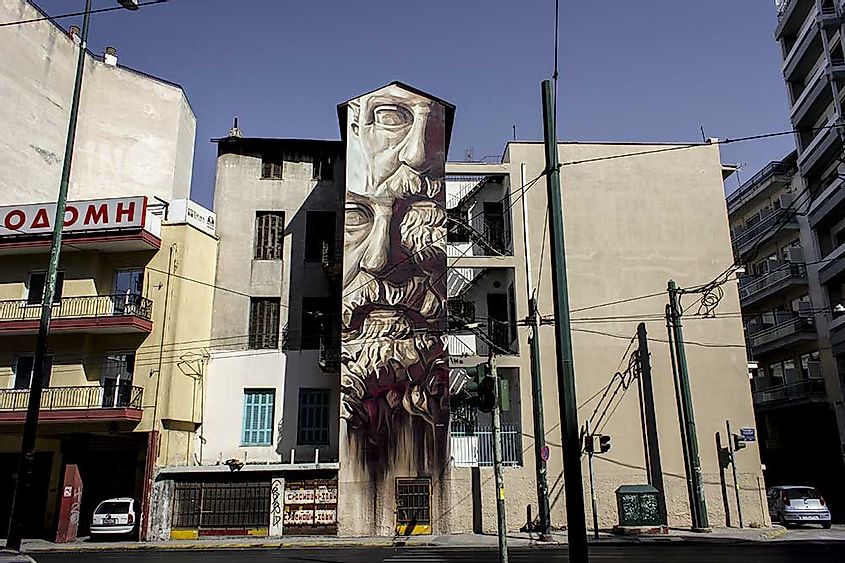 Mural 'System of a Fraud' by renown street artist INO. It depicts Solon, the father of democracy, on both political sides, left and right, both collapsing, near Omonia Square, Athens 