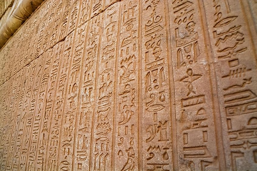 Massive columns inside beautiful Egyptian landmark with hieroglyphics, and ancient symbols.