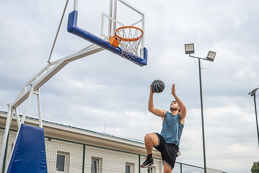 Man scoring a dunk on an outdoor basketball court