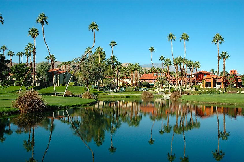A resort in Palm Springs, California with water and palm trees.