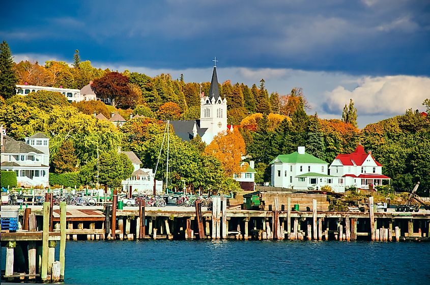 Lake houses along Lake Huron surrounded by vibrant autumn foliage on Mackinac Island, Michigan.