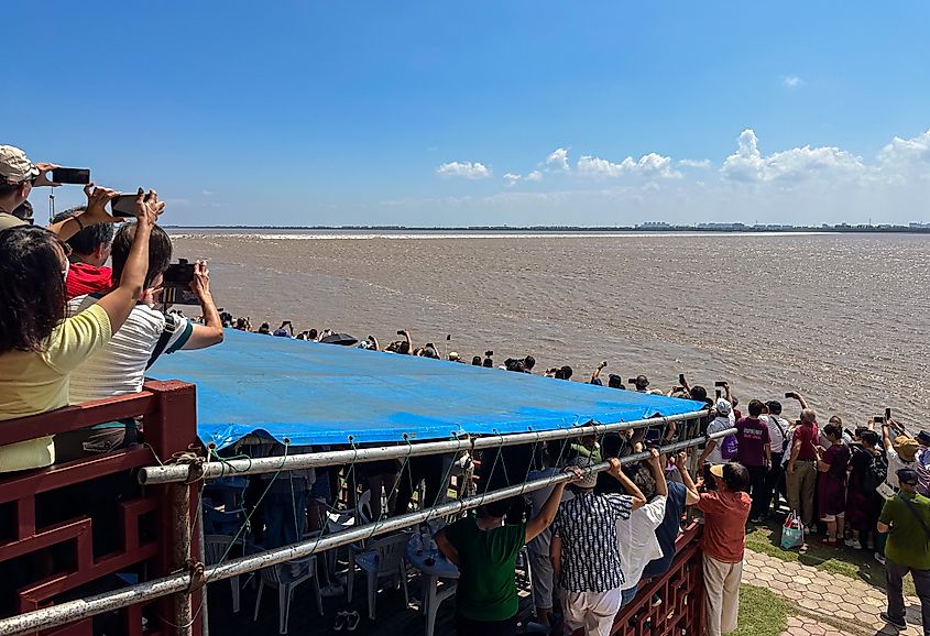 Massive people watching wonderful Qiantang River tide at Tide Bore Watching Park, Haining, Jiaxing, Zhejiang, China.