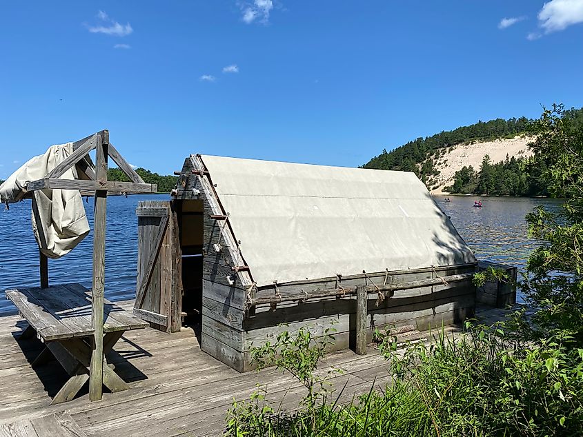 An old tent/cabin docking station on a wide river amongst the forest sand dunes.