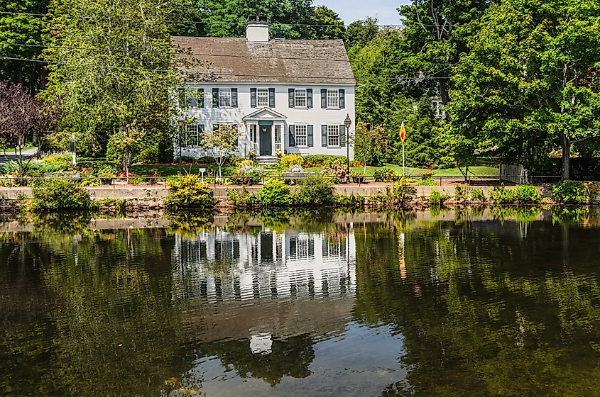 Historic New England house reflected in Shawme Lake, Sandwich, Massachusetts, USA. Via Shutterstock / Conny Pokorny
