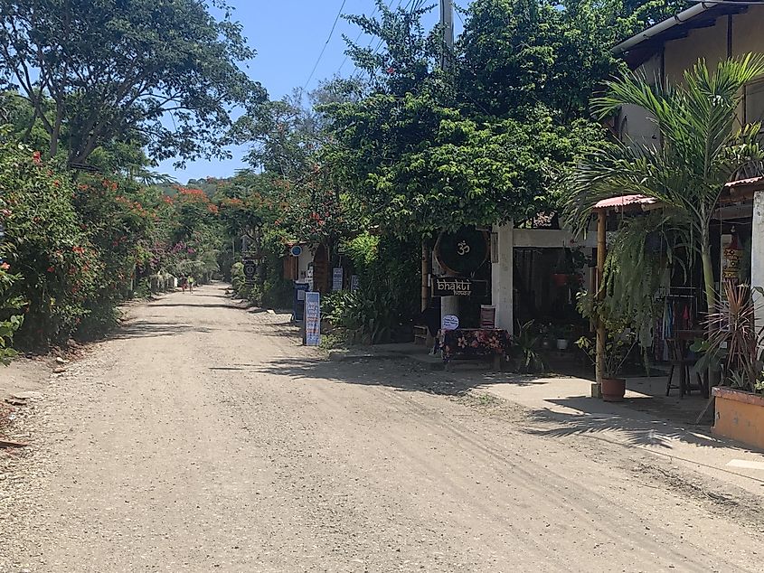 A dusty road leading through a small South American town