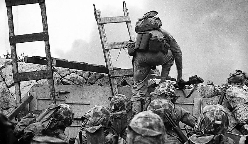 First Lieutenant Baldomero Lopez, USMC, leads the 3rd Platoon, Company A, 1st Battalion, 5th Marines over the seawall on the northern side of Red Beach, as the second assault wave lands, 15 September 1950, during the Inchon invasion. 