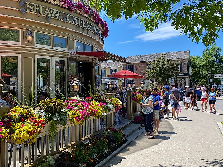 A crowded sidewalk outside of the flower-lined Shaw Cafe & Wine Bar