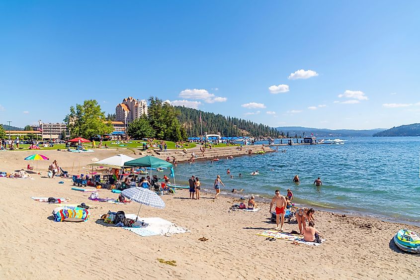 A busy summer day along the sandy beach of Lake Coeur d'Alene at Independence Point, in the downtown resort district of rural Coeur d'Alene, Idaho.