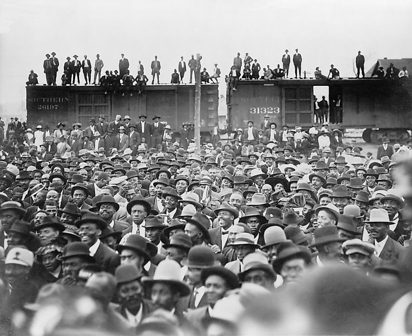 Listening to Booker T. Washington. An African American audience, some standing on railroad box cars, in New Orleans, Louisiana. 1912.