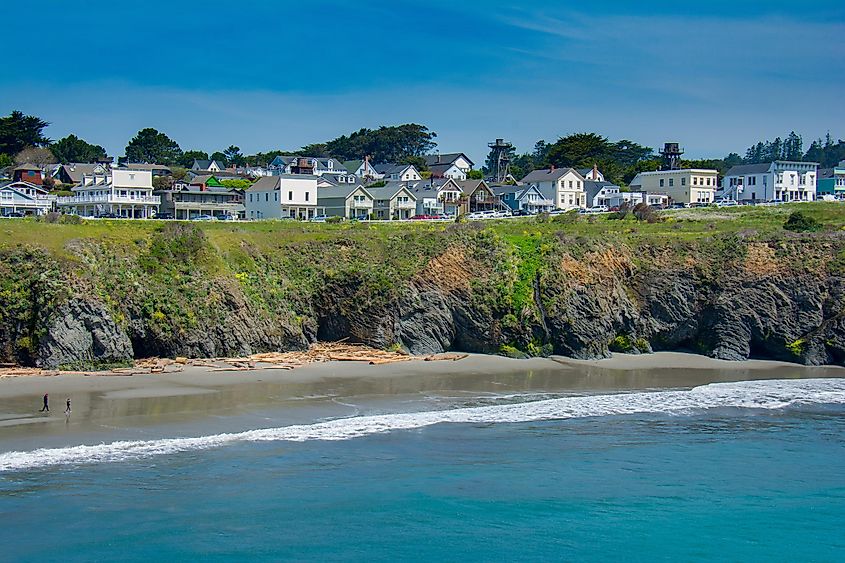 The seacoast village of Mendocino, California lines an ocean headland at low tide on a sunny spring afternoon.