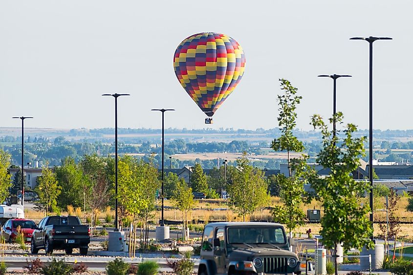 A hot air balloon just after take off near a parking lot in Lafayette, Colorado.
