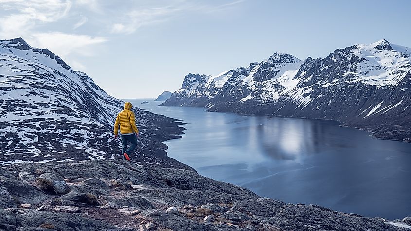 Man solo travel hiking in scandinavian mountains active healthy lifestyle adventure travel vacation. Travel concept of discovering, learning and observing nature.